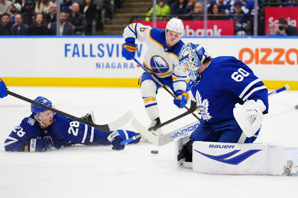 Toronto Maple Leafs goaltender Joseph Woll (60) makes a save as Troy Stecher (28) defends against Zach Benson (6) during third period NHL action in Toronto, Ontario, Tuesday, Jan. 27, 2026. (Frank Gunn/The Canadian Press via AP)
