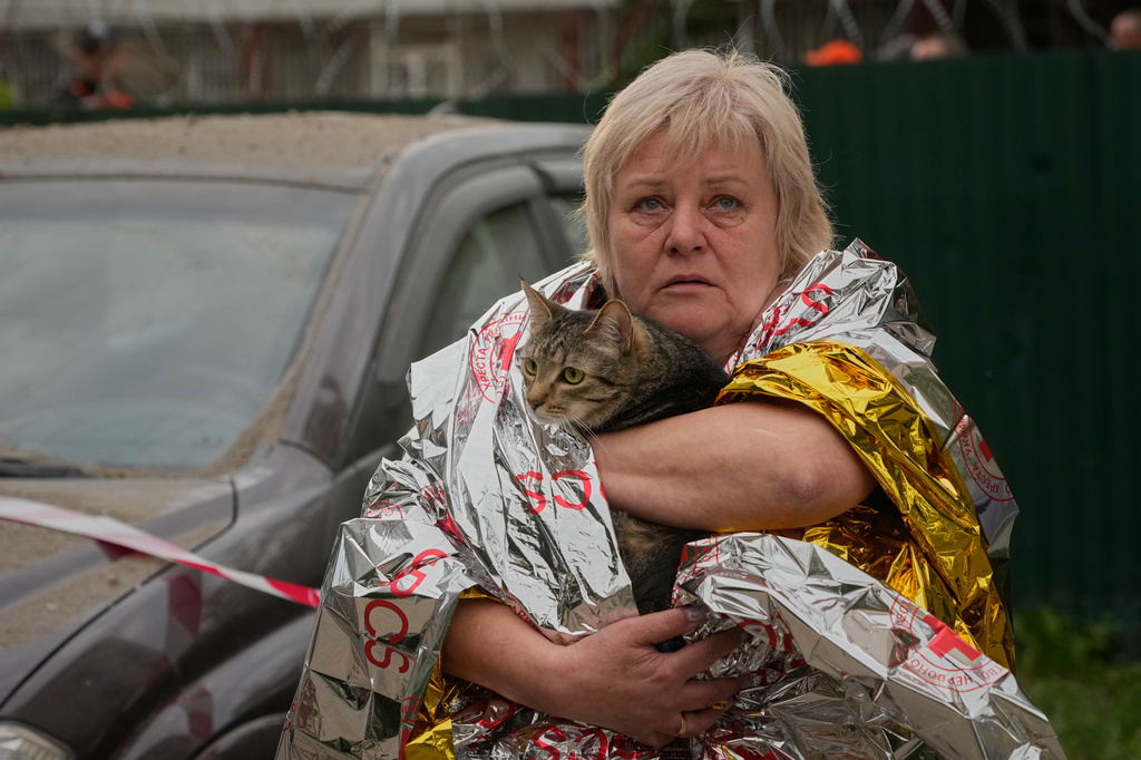 A woman carries her cat out of a damaged multistory apartment building following a Russian missile attack in Kyiv, Ukraine, Monday, July 6, 2026. (AP Photo/Efrem Lukatsky)