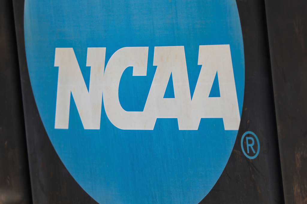 FILE - NCAA logo displayed on the fence before an NCAA softball game between Jacksonville and FGCU, March 24, 2024, in Jacksonville, Fla. (AP Photo/Gary McCullough, File)