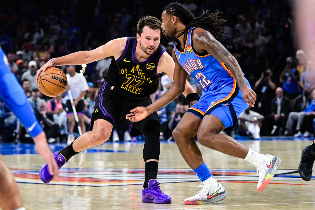 Los Angeles Lakers forward/guard Luka Dončić (77) drives against Oklahoma City Thunder guard Cason Wallace (22) during the first half of an NBA basketball game Thursday, April. 2, 2026, in Oklahoma City. (AP Photo/Gerald Leong)