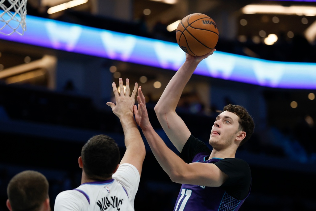 Charlotte Hornets center Ryan Kalkbrenner, right, shoots over Utah Jazz center Jusuf Nurkic, second from right, during the second half of an NBA basketball game in Charlotte, N.C., Sunday, Nov. 2, 2025. (AP Photo/Nell Redmond)