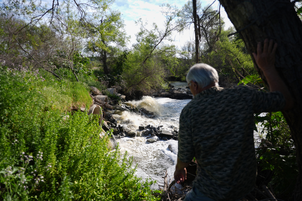 Steve Egger looks over what scientists call "the Saturn hot spot," a section of the Tijuana River where the contaminated water splashes out of pipes and creates pools of foam near his home Friday, March 6, 2026, in San Diego. (AP Photo/Gregory Bull)