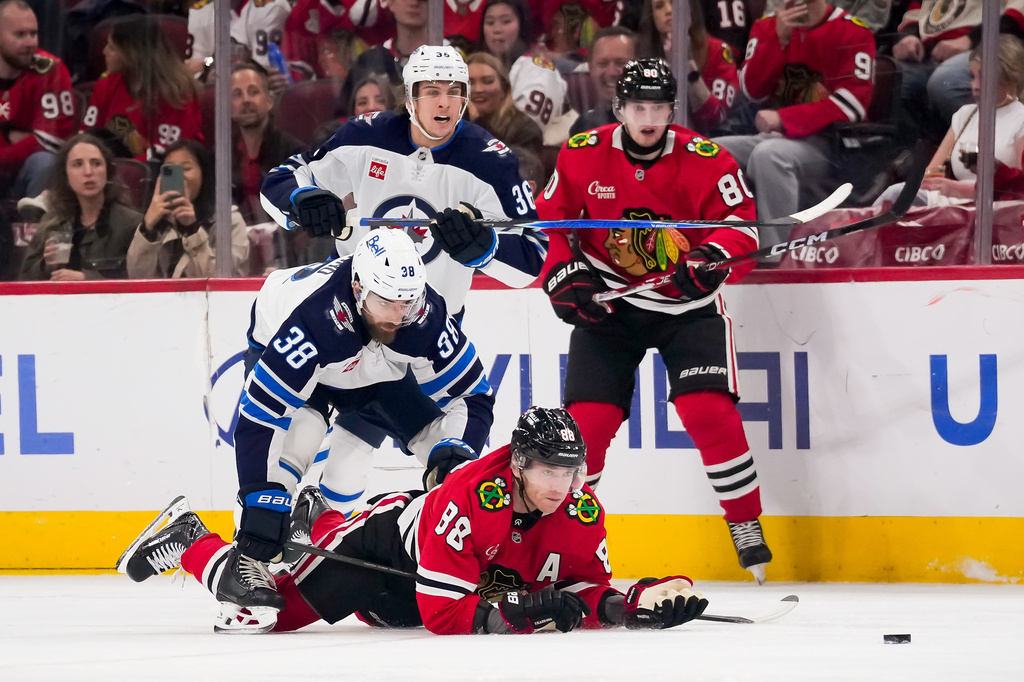 Chicago Blackhawks right wing Patrick Kane (88) looks at the puck after being checked by Winnipeg Jets defenseman Mario Ferraro (38) during the first period of an NHL hockey game, Thursday, Oct. 15, 2026, in Chicago. (AP Photo/Harry Figiel)