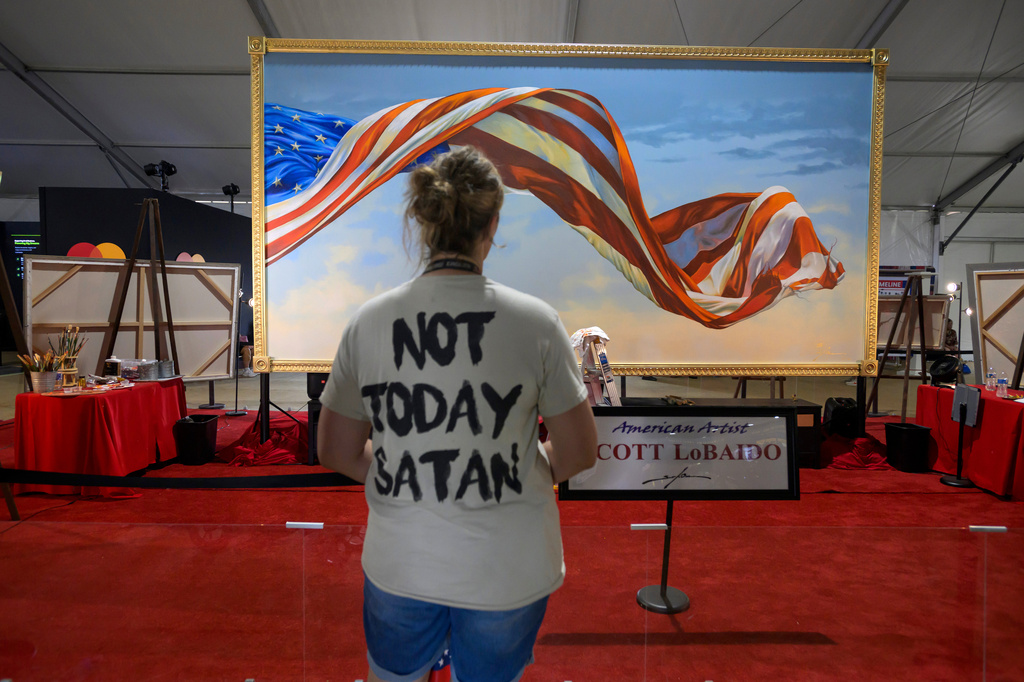 A woman pauses to view a painting by artist Scott LoBaido at the Great American State Fair on the National Mall, Thursday, July 9, 2026, in Washington. (AP Photo/Rod Lamkey, Jr.)