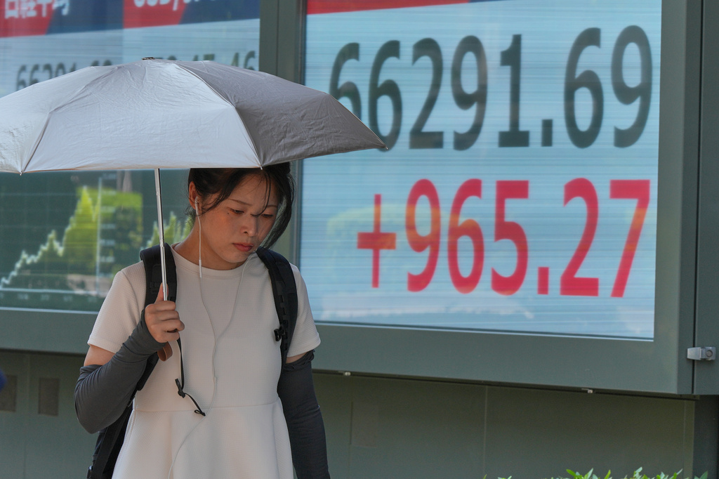 A person walks in front of an electronic stock board showing Japan's Nikkei index at a securities firm Thursday, Aug. 20, 2026, in Tokyo. (AP Photo/Eugene Hoshiko)