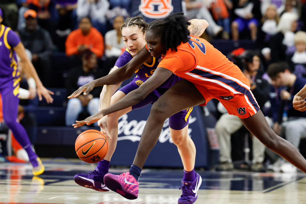 LSU forward Grace Knox (2) and Auburn center Arek Angui (23) reach for a loose ball during the first half of an NCAA college basketball game Sunday, Feb. 8, 2026, in Auburn, Ala. (AP Photo/Butch Dill)