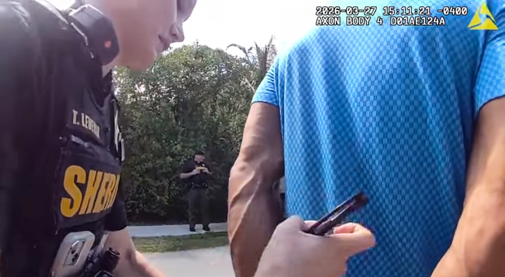 In this image taken from police body camera video released by the Martin County, Fla., Sheriff's Office, golfer Tiger Woods is taken into custody by sheriff's deputies following a car crash in Jupiter Island, Fla., Friday, March 27, 2026. (Martin County Sheriff's Office via AP)