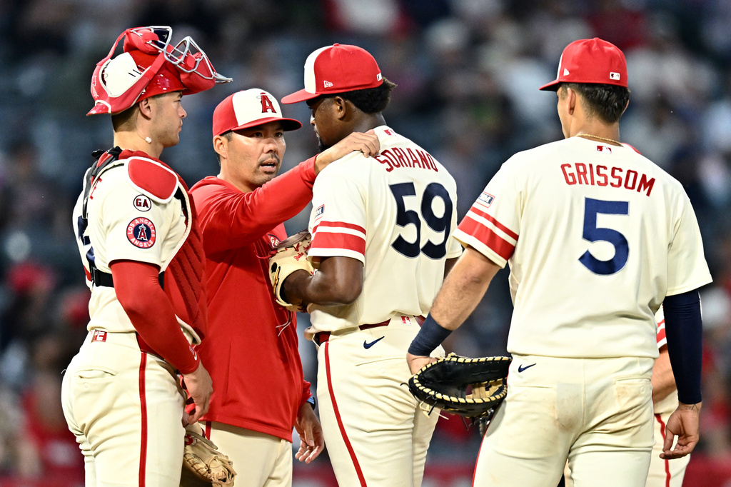 Los Angeles Angels manager Kurt Suzuki, second from left, speaks with pitcher José Soriano (59) before a pitching change during the fifth inning of a baseball game against the Colorado Rockies, Monday, June 1, 2026, in Anaheim, Calif. (AP Photo/William Liang)