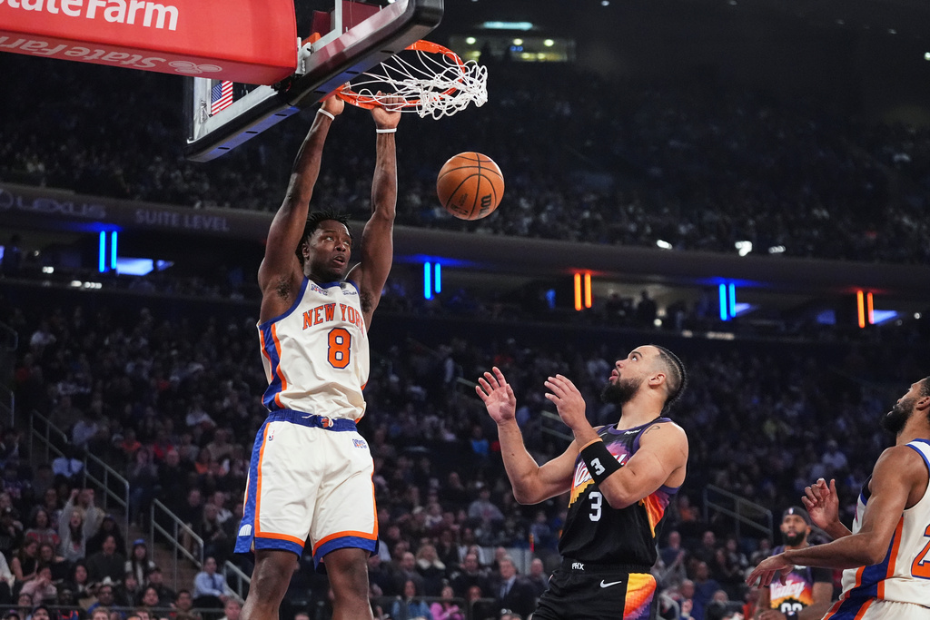 New York Knicks' Og Anunoby (8) dunks the ball in front of Phoenix Suns' Dillon Brooks (3) during the first half of an NBA basketball game Saturday, Jan. 17, 2026, in New York. (AP Photo/Frank Franklin II)
