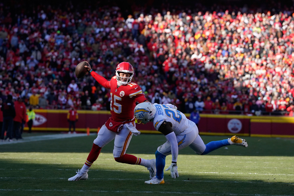 Kansas City Chiefs quarterback Patrick Mahomes (15) scrambles as Los Angeles Chargers safety Tony Jefferson (23) defends during the first half of an NFL football game Sunday, Dec. 14, 2025, in Kansas City, Mo. (AP Photo/Ed Zurga)