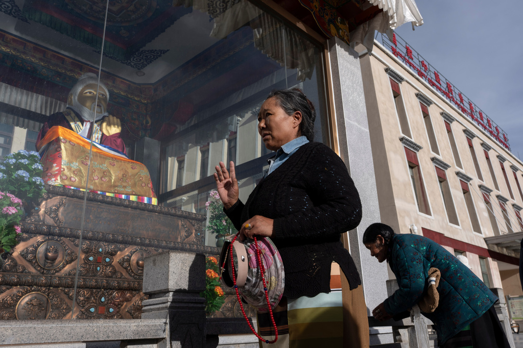 Women perform circumambulations around a statue of Tibetan medical master Yutok Nyingma Yonten Gonpo outside the Xizang Autonomous Region Hospital of Tibetan Medicine in Lhasa, in western China's Tibet Autonomous Region on Wednesday, July 22, 2026 as seen during a government organized visit for foreign journalists. (AP Photo/Ng Han Guan)