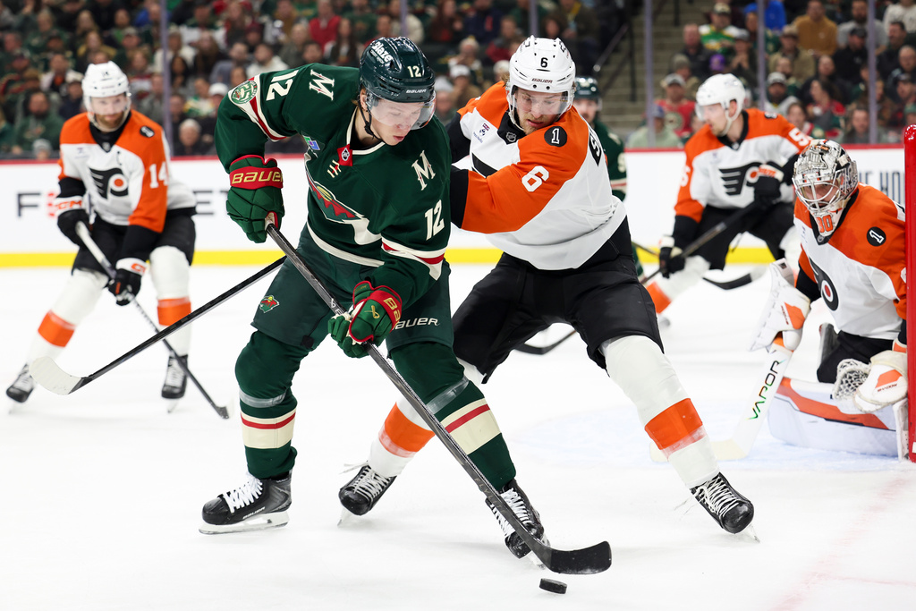 Minnesota Wild left wing Matt Boldy (12) handles the puck against Philadelphia Flyers defenseman Travis Sanheim (6) during the first period of an NHL hockey game Thursday, March 12, 2026, in St. Paul, Minn. (AP Photo/Ellen Schmidt)