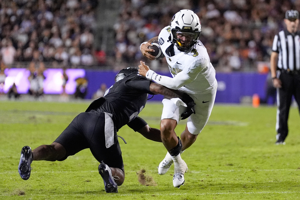 Colorado quarterback Kaidon Salter (3) attempts to escape the grasp of TCU safety Jamel Johnson, left, in the first half of an NCAA college football game Saturday, Oct. 4, 2025, in Fort Worth, Texas. (AP Photo/Tony Gutierrez)