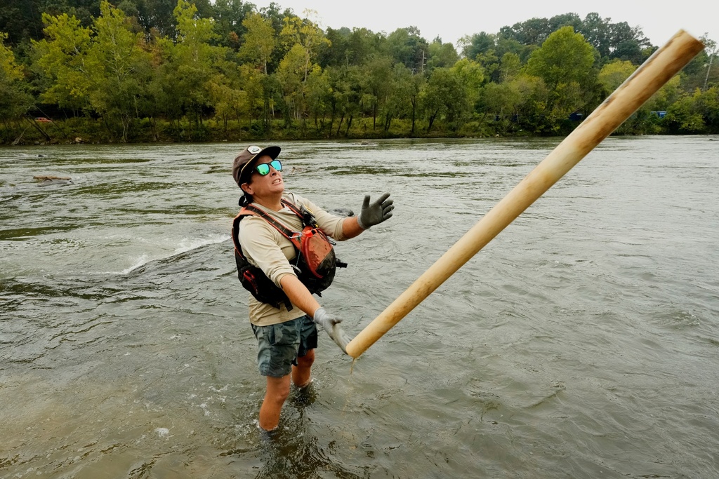 Leslie Beninato, river cleanup logistics manager of MountainTrue, removes a PVC pipe from the French Broad River on Wednesday, Sept. 17, 2025, in Asheville, N.C. (AP Photo/Chris Carlson)