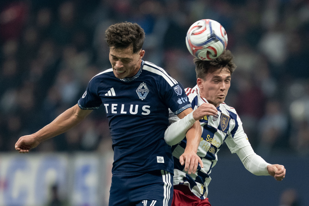 Vancouver Whitecaps' Sebastian Berhalter, left, and Real Salt Lake's Zach Booth (23) jump for the ball during the first half of an MLS soccer match in Vancouver, on Saturday, Feb. 21, 2026. (Ethan Cairns/The Canadian Press via AP)