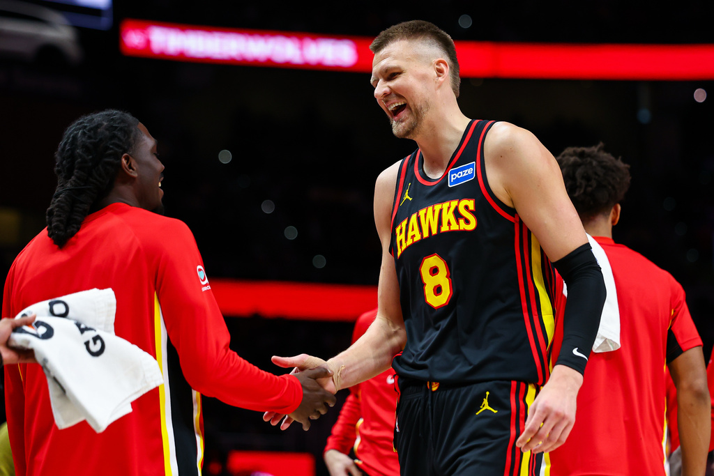 Atlanta Hawks center Kristaps Porzingis (8) greets guard Keaton Wallace during the first half of an NBA basketball game against the Minnesota Timberwolves, Wednesday, Dec. 31, 2025, in Atlanta. (AP Photo/Colin Hubbard)