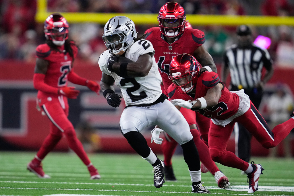 Las Vegas Raiders running back Ashton Jeanty, middle, runs past Houston Texans cornerback Myles Bryant, right, to score during the second half of an NFL football game, Sunday, Dec. 21, 2025, in Houston. (AP Photo/Ashley Landis)