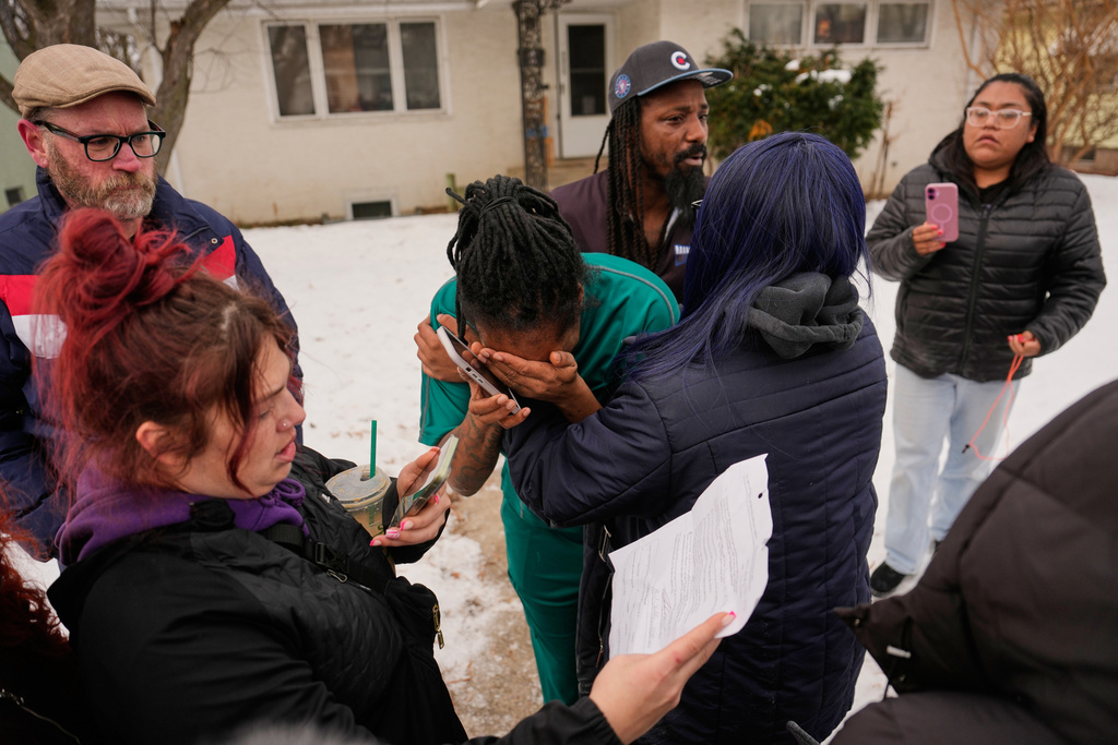 A family member, center, reacts after federal immigration officers make an arrest Sunday, Jan. 11, 2026, in Minneapolis. (AP Photo/John Locher)