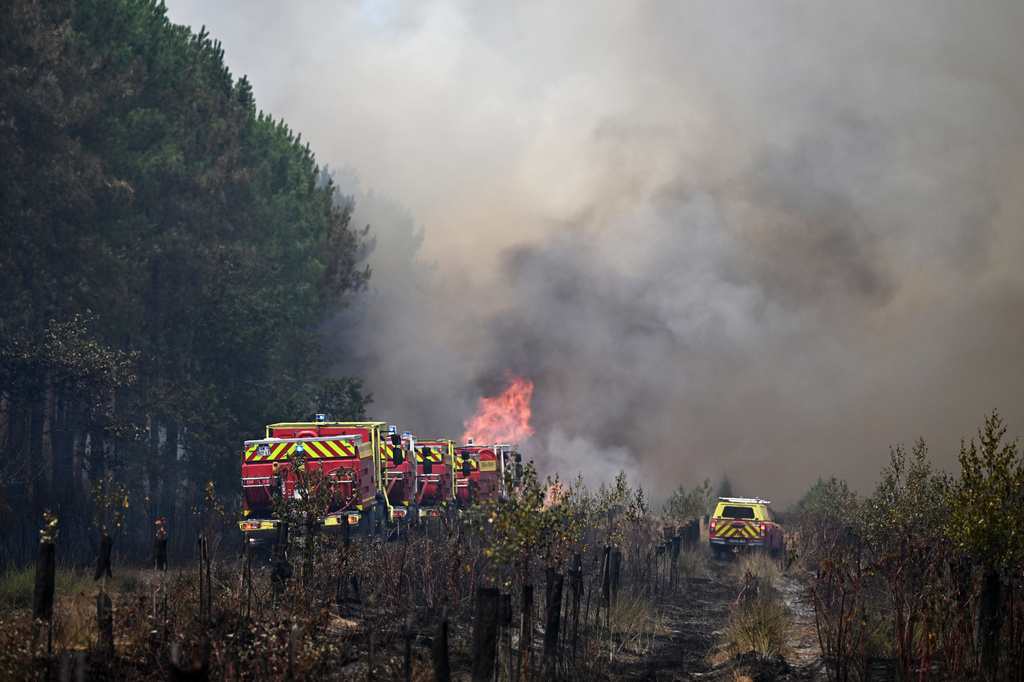 Firefighters tackle a blaze as wildfires rage near Le Las, outside Bordeaux, France, Monday, July 27, 2026. (AP Photo/Emma Da Silva)