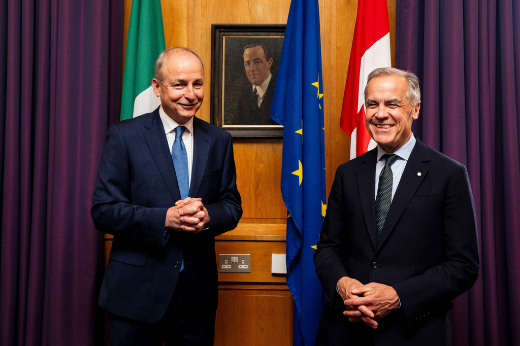 Prime Minister Mark Carney, right, poses for a photograph with Micheal Martin, Ireland's head of government, in front of a portrait of Harry Boland, at the Government Buildings in Dublin, on Saturday, June 13, 2026. (Christopher Katsarov /The Canadian Press via AP)