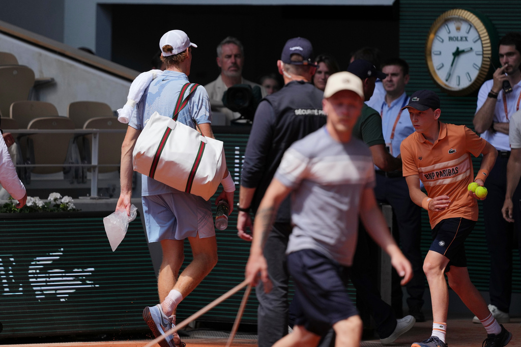 Jannik Sinner of Italy, left, leaves the court holding a bag with ice during the second round men's singles tennis match against Juan Manuel Cerundolo of Argentina at the French Open tennis tournament in Paris, Thursday, May 28, 2026. (AP Photo/Thibault Camus)