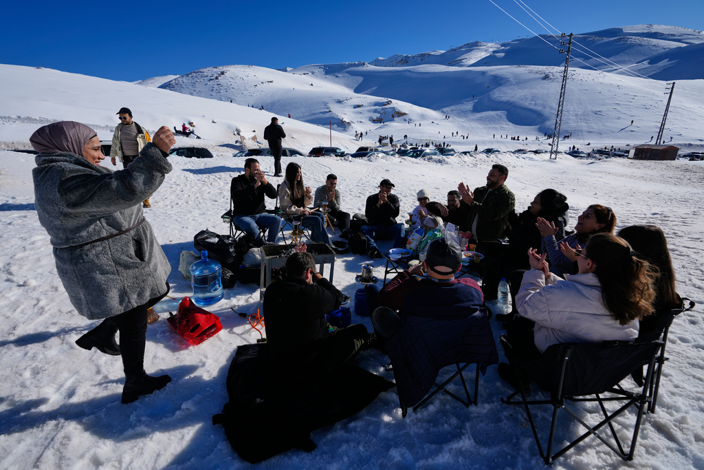 People gather to picnic and socialize in the snow near the Mzaar-Kfardebian ski resort northeast of Beirut, Lebanon, Saturday, Jan. 3, 2026. (AP Photo/Hassan Ammar)