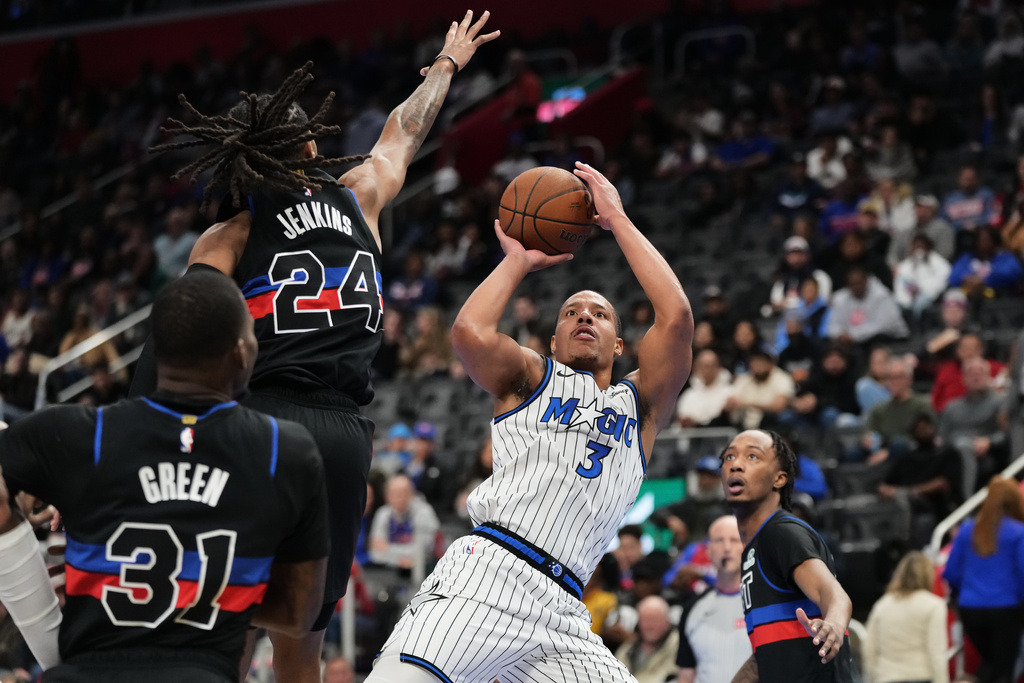 Orlando Magic guard Desmond Bane, right, shoots against Detroit Pistons guard Daniss Jenkins, center, and guard Javonte Green during the first half of an NBA Cup basketball game, Friday, Nov. 28, 2025, in Detroit. (AP Photo/Ryan Sun)