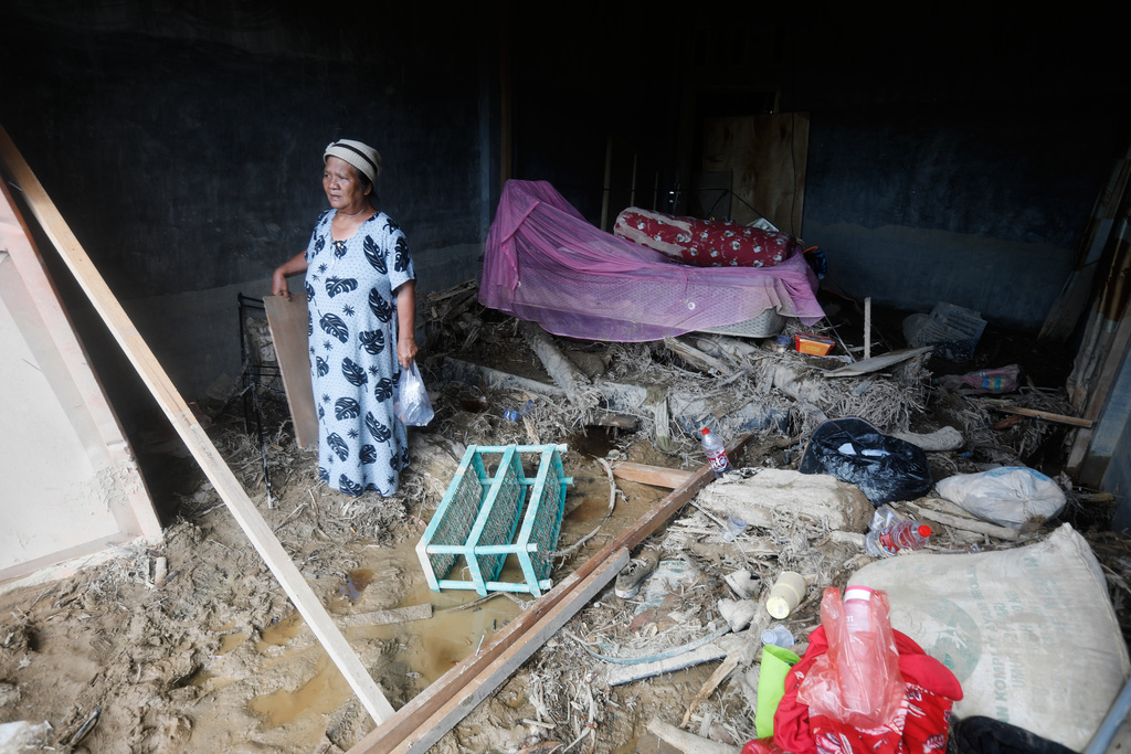 A woman stands inside a damaged house in a village affected by a flash flood in Batang Toru, North Sumatra, Indonesia, Monday, Dec. 1, 2025. (AP Photo/Binsar Bakkara)