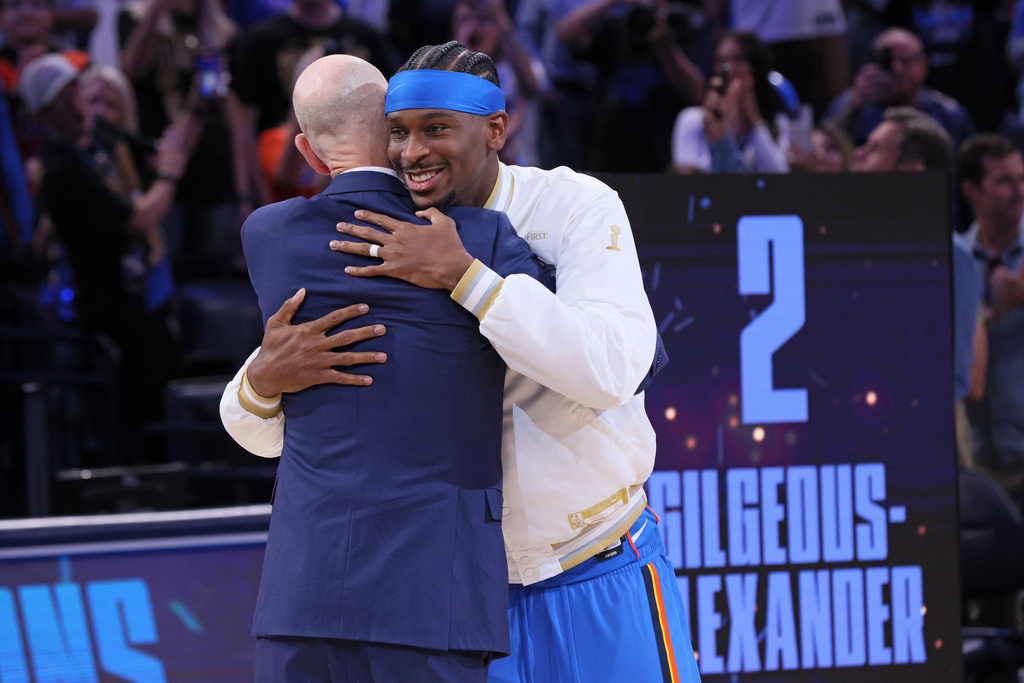 Oklahoma City Thunder guard Shai Gilgeous-Alexander, right, hugs NBA commissioner Adam Silver during the championship ring ceremony before an NBA basketball game against the Houston Rockets, Tuesday, Oct. 21, 2025, in Oklahoma City. (AP Photo/Nate Billings)