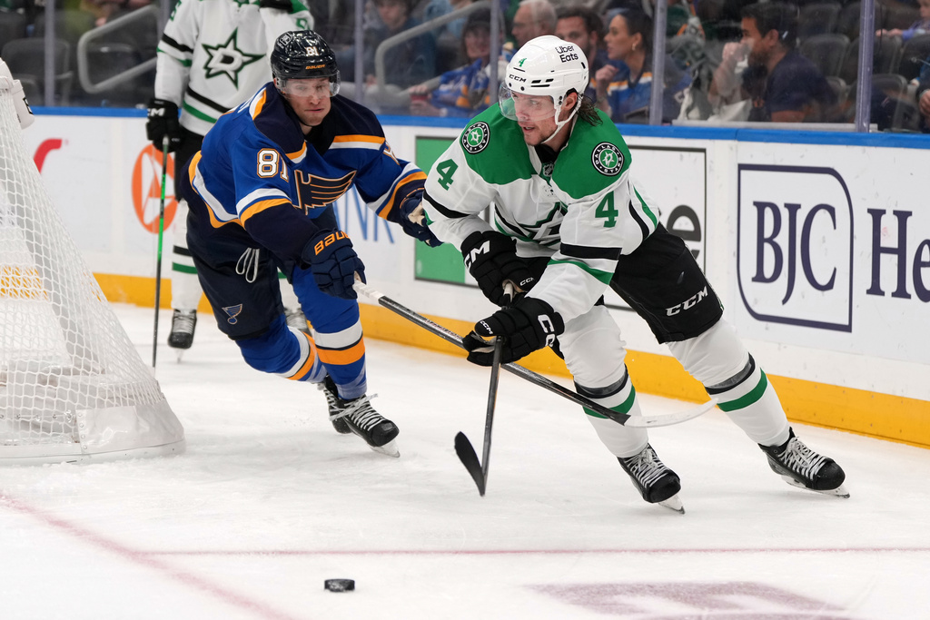 Dallas Stars' Miro Heiskanen (4) passes as St. Louis Blues' Dylan Holloway (81) defends during the second period of an NHL hockey game Saturday, Oct. 18, 2025, in St. Louis. (AP Photo/Jeff Roberson)