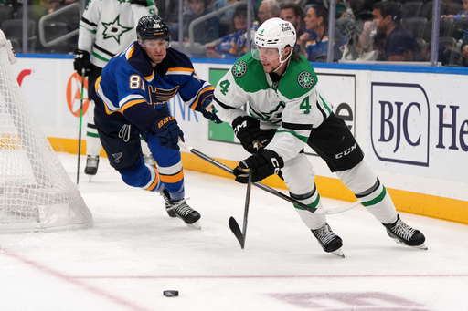 Dallas Stars' Miro Heiskanen (4) passes as St. Louis Blues' Dylan Holloway (81) defends during the second period of an NHL hockey game Saturday, Oct. 18, 2025, in St. Louis. (AP Photo/Jeff Roberson) Dallas Stars' Miro Heiskanen (4) passes as St. Louis Blues' Dylan Holloway (81) defends during the second period of an NHL hockey game Saturday, Oct. 18, 2025, in St. Louis. (AP Photo/Jeff Roberson)