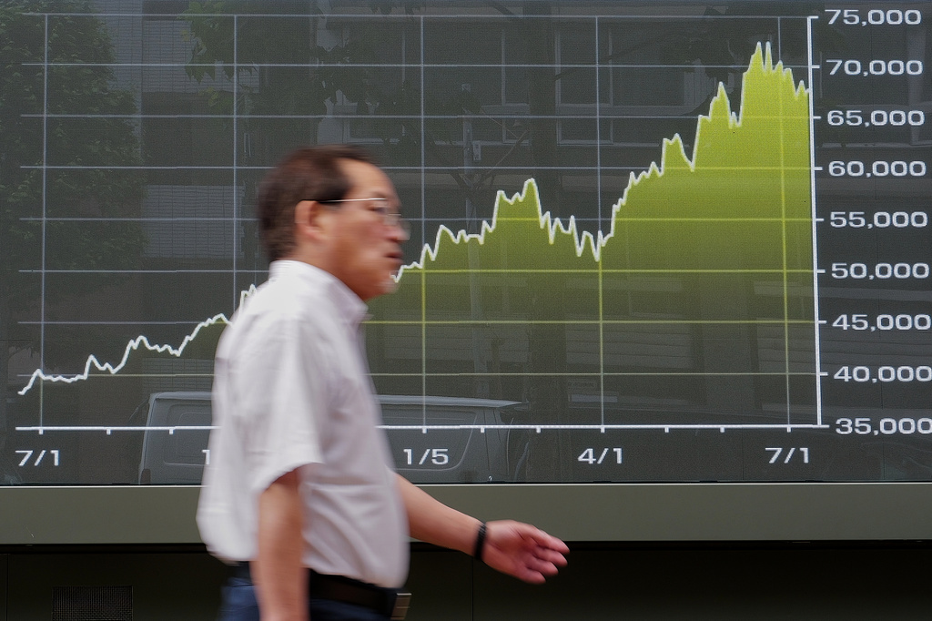 A man walks in front of an electronic stock board showing Japan's Nikkei 225 index at a securities firm Wednesday, July 15, 2026, in Tokyo. (AP Photo/Eugene Hoshiko)