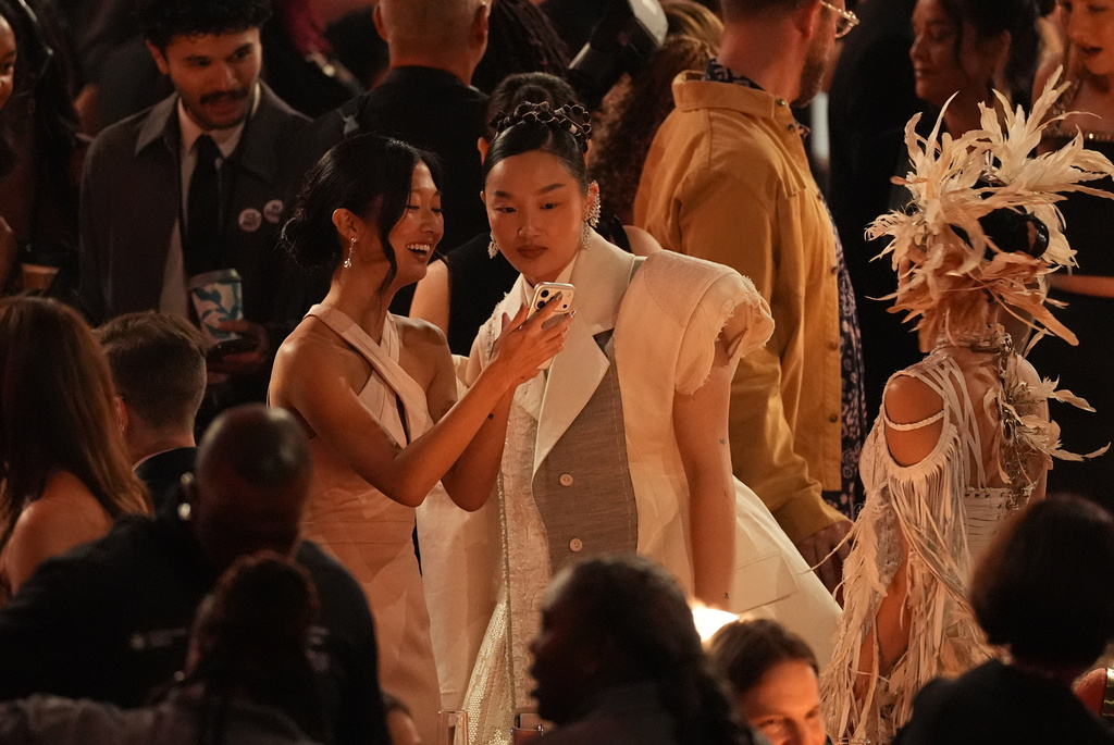 Audrey Nuna, center, and Rei Ami, right, speak in the audience during the 68th annual Grammy Awards on Sunday, Feb. 1, 2026, in Los Angeles. (AP Photo/Chris Pizzello)