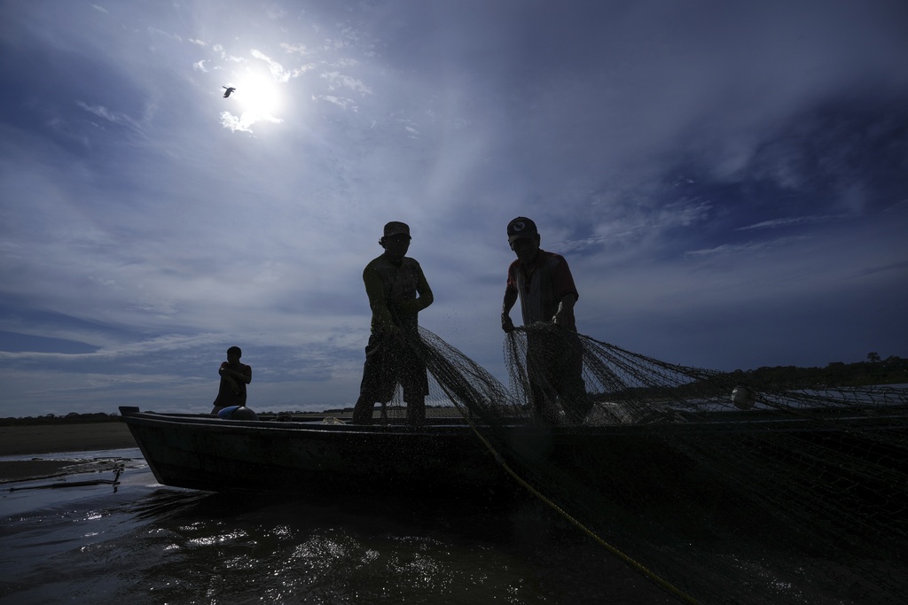 FILE - Men look for fish in the Amazon River amid a drought on the outskirts of Leticia, Colombia, Monday, Oct. 21, 2024. (AP Photo/Ivan Valencia, File)