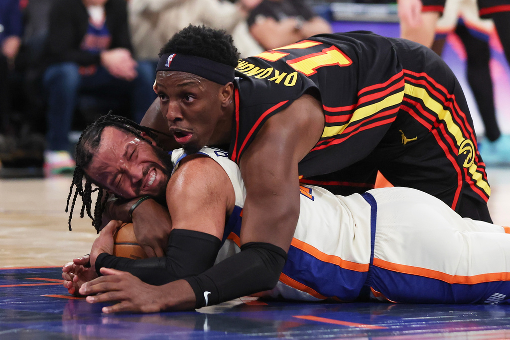 New York Knicks guard Jalen Brunson, bottom, and Atlanta Hawks forward Onyeka Okongwu (17) battle for the ball during second half of an NBA basketball game, Friday, Jan. 2, 2026, in New York. (AP Photo/Heather Khalifa)