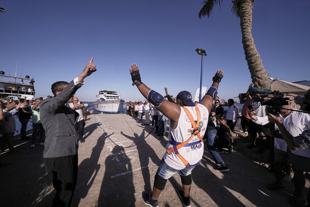Egyptian wrestler Ashraf Mahrous, better known as Kabonga, celebrates as he pulls a 700-ton ship across the water using only a rope held in his teeth at the marina in the Red Sea resort of Hurghada, Egypt, Saturday, Sept. 27, 2025. (AP Photo/Amr Nabil)