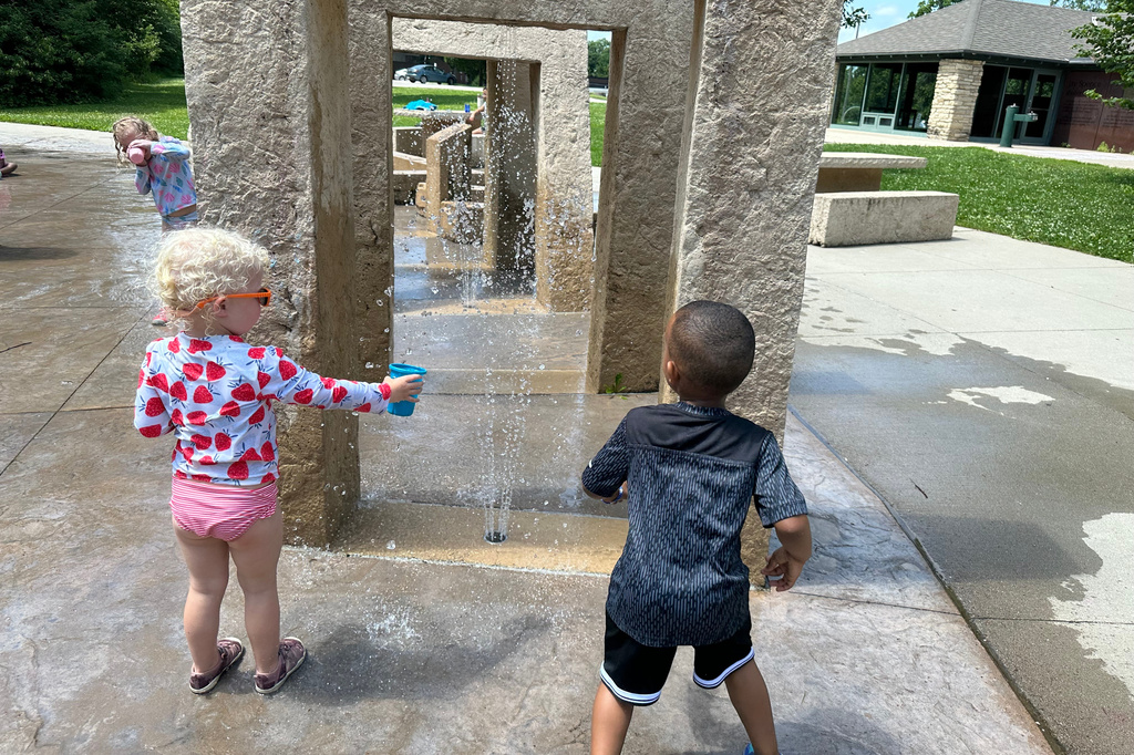 Children play at a water sprayground in Des Moines, Iowa, Monday, June 29, 2026. (AP Photo/Hannah Fingerhut)