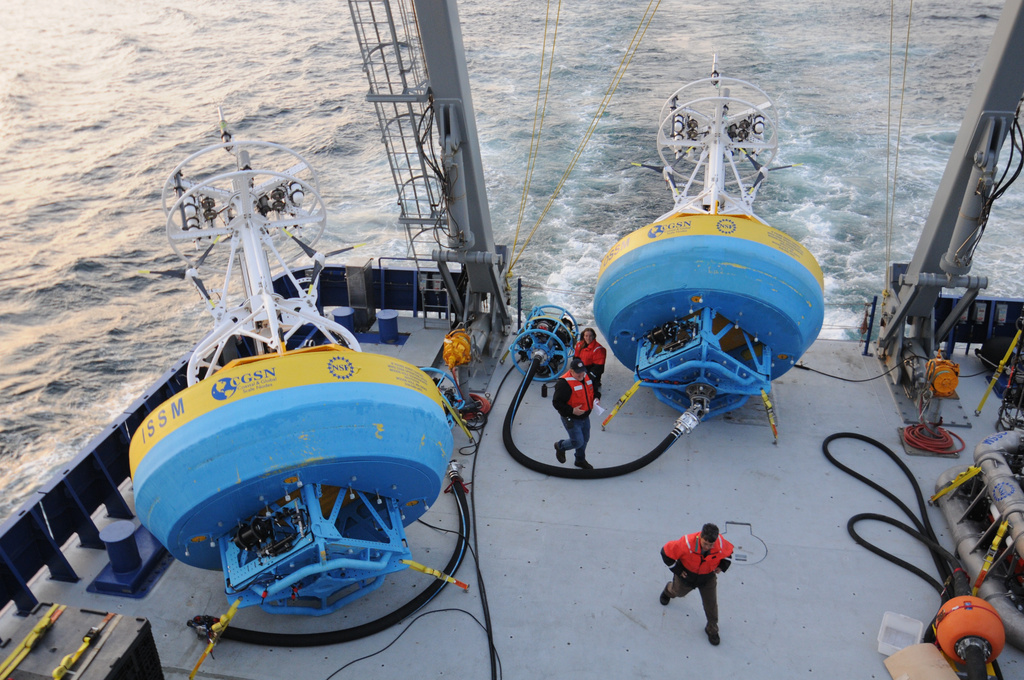 In this 2021 image provided by Woods Hole Oceanographic Institution, workers walk near buoys used to gather data at Pioneer New England shelf off the coast of Martha’s Vineyard, Mass. (Véronique LaCapra/Woods Hole Oceanographic Institution via AP)