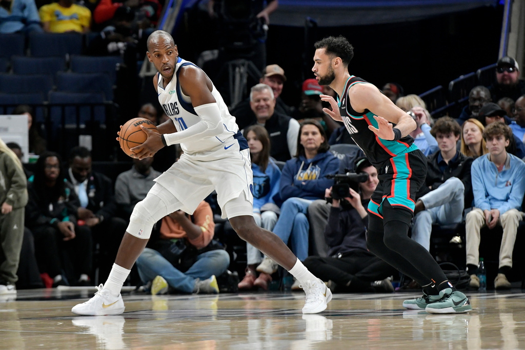 Dallas Mavericks forward Khris Middleton, left, handles the ball against Memphis Grizzlies forward Tyler Burton in the first half of an NBA basketball game Thursday, March 12, 2026, in Memphis, Tenn. (AP Photo/Brandon Dill)
