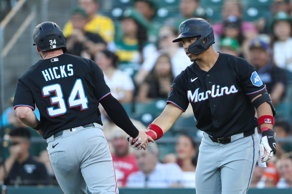 Miami Marlins' Heriberto Hernández, right, congratulates teammate Liam Hicks (34) after scoring on a sacrifice fly during the second inning of a baseball game against the Athletics, Friday, July 3, 2026, in West Sacramento, Calif. (AP Photo/Scott Marshall)