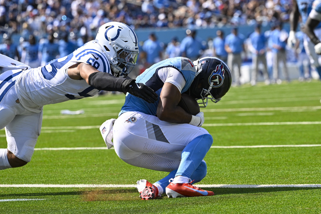 Tennessee Titans wide receiver Elic Ayomanor (5) makes a catch for a touchdown under Indianapolis Colts linebacker Austin Ajiake (58) during the second half of an NFL football game Sunday, Sept. 21, 2025, in Nashville, Tenn. (AP Photo/John Amis)