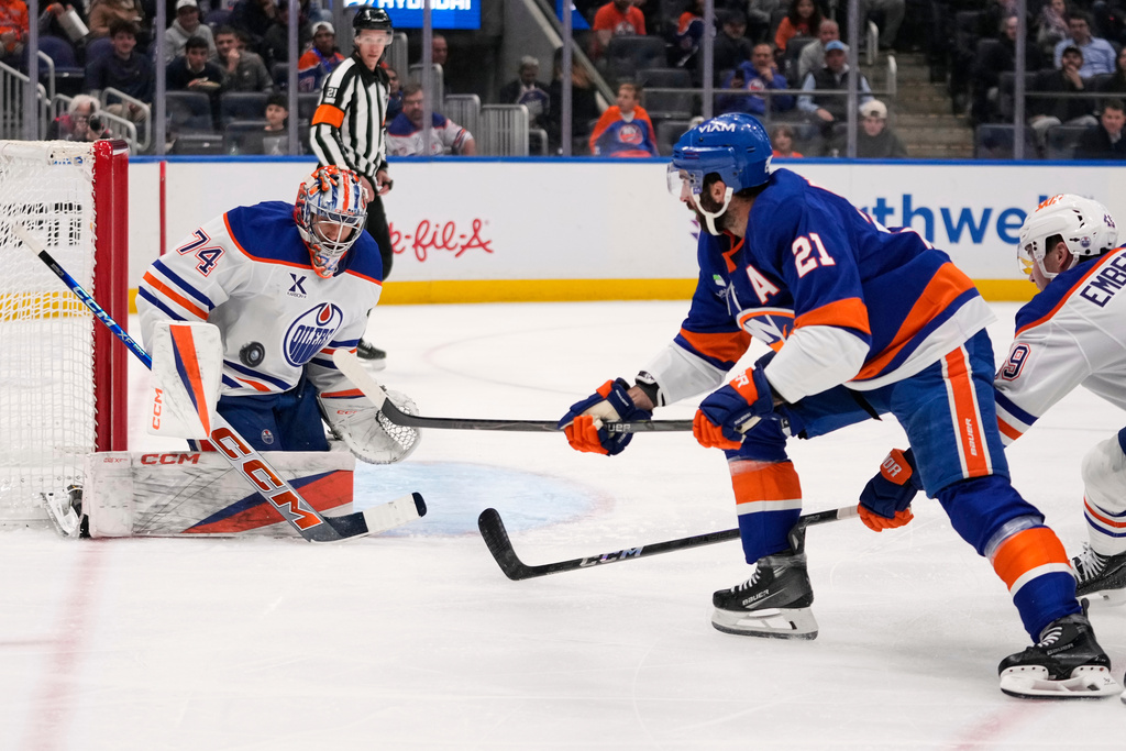 Edmonton Oilers goaltender Stuart Skinner (74) stops a shot by New York Islanders' Kyle Palmieri (21) during the second period of an NHL hockey game Thursday, Oct. 16, 2025, in Elmont, N.Y. (AP Photo/Frank Franklin II)