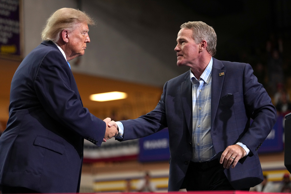 Sen. Jon Husted, R-Ohio, right, shakes the hand of President Donald Trump after speaking during an event at Butler High School in Vandalia, Ohio, Saturday, Oct. 3, 2026. (AP Photo/Mark Schiefelbein)