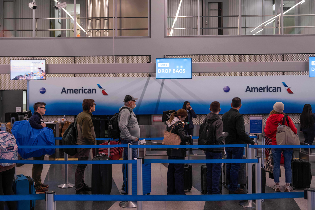 People wait in line to check in to American Airlines flights at Chicago O'Hare International Airport in Chicago, Ill., Sunday, Nov. 9, 2025. (AP Photo/Adam Gray)