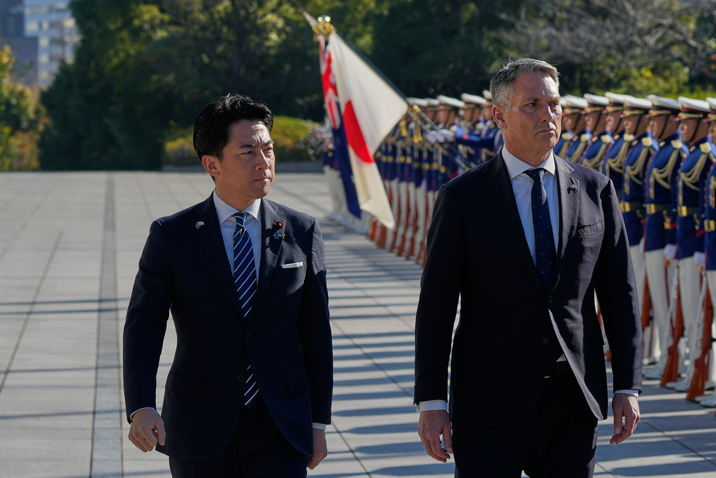 Japanese Minister of Defense Shinjiro Koizumi, left, and Australian counterpart Richard Marles, right, review an honor guard ahead of a bilateral meeting at the defense ministry Sunday, Dec. 7, 2025, in Tokyo. (AP Photo/Eugene Hoshiko, Pool)