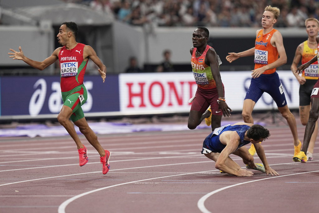 Portugal's Isaac Nader, left, reacts after crossing the finish line to win gold medal as Britain's Jake Wightman falls on the track in the men's 1,500 meters final at the World Athletics Championships in Tokyo, Wednesday, Sept. 17, 2025. (AP Photo/Eugene Hoshiko)