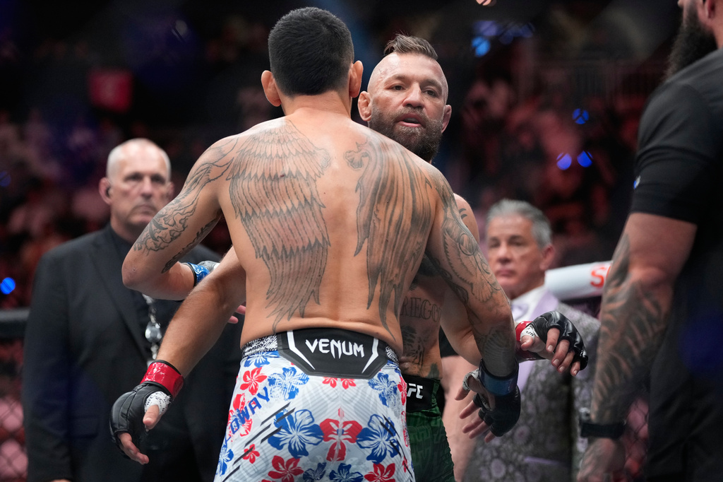 Conor McGregor, right, embraces Max Holloway after McGregor lost in a welterweight fight at the UFC 329 mixed martial arts event Saturday, July 11, 2026, in Las Vegas. (AP Photo/John Locher)