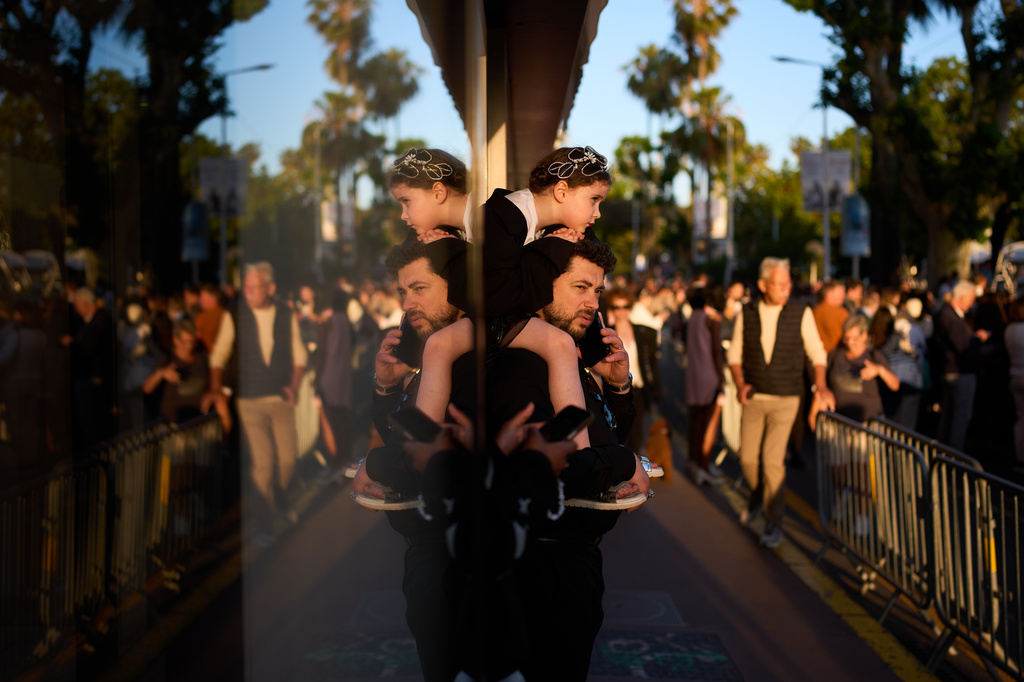 People wait to try and get a view of the red carpet during the 79th international film festival, Cannes, southern France, Wednesday, May 13, 2026. (AP Photo/John Locher)