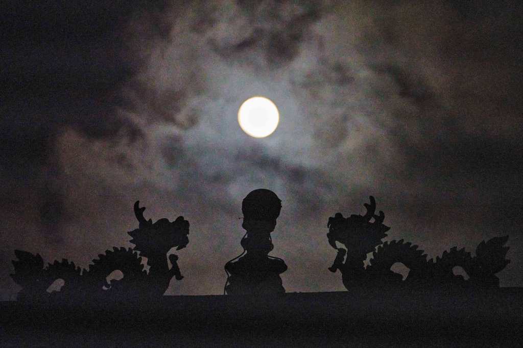 The Harvest Supermoon rises over the Thien Tau Temple in Chinatown Los Angeles Monday, Oct. 6, 2025. (AP Photo/Damian Dovarganes)