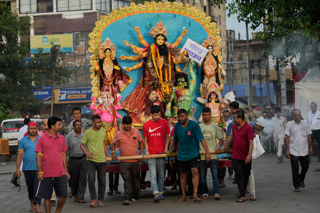 Devotees carry an idol of Hindu goddess Durga to immerse in river Brahmaputra in Guwahati, Thursday, Oct. 2, 2025. (AP Photo/Anupam Nath)